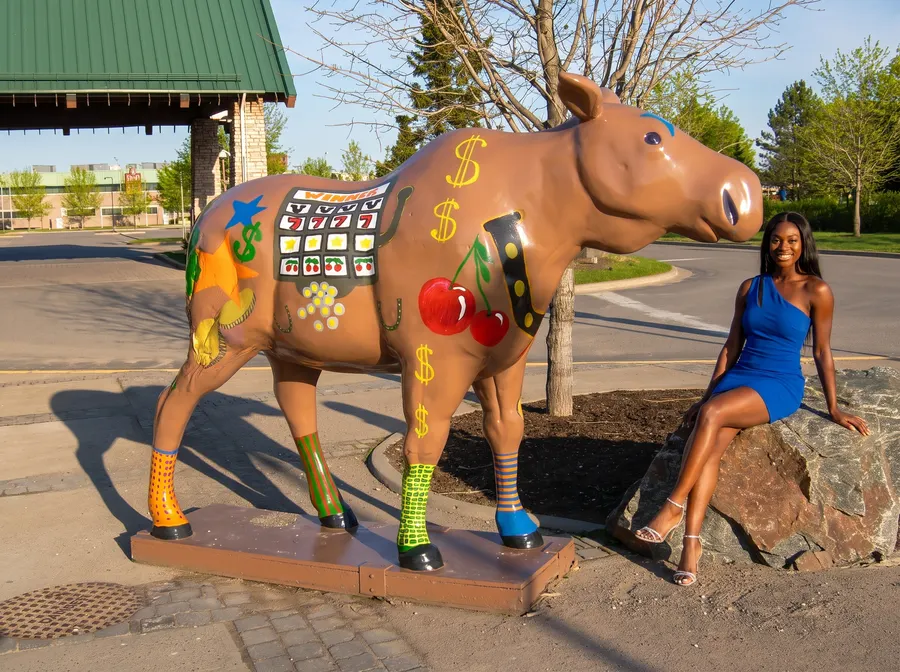 Woman on a boulder beside the painted casino moose